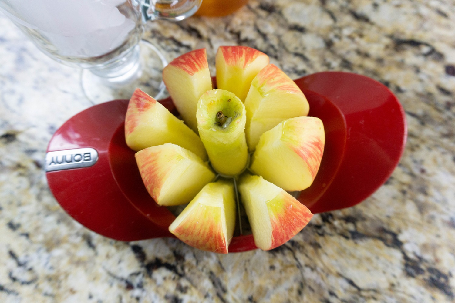 A cored apple in an apple slicer.