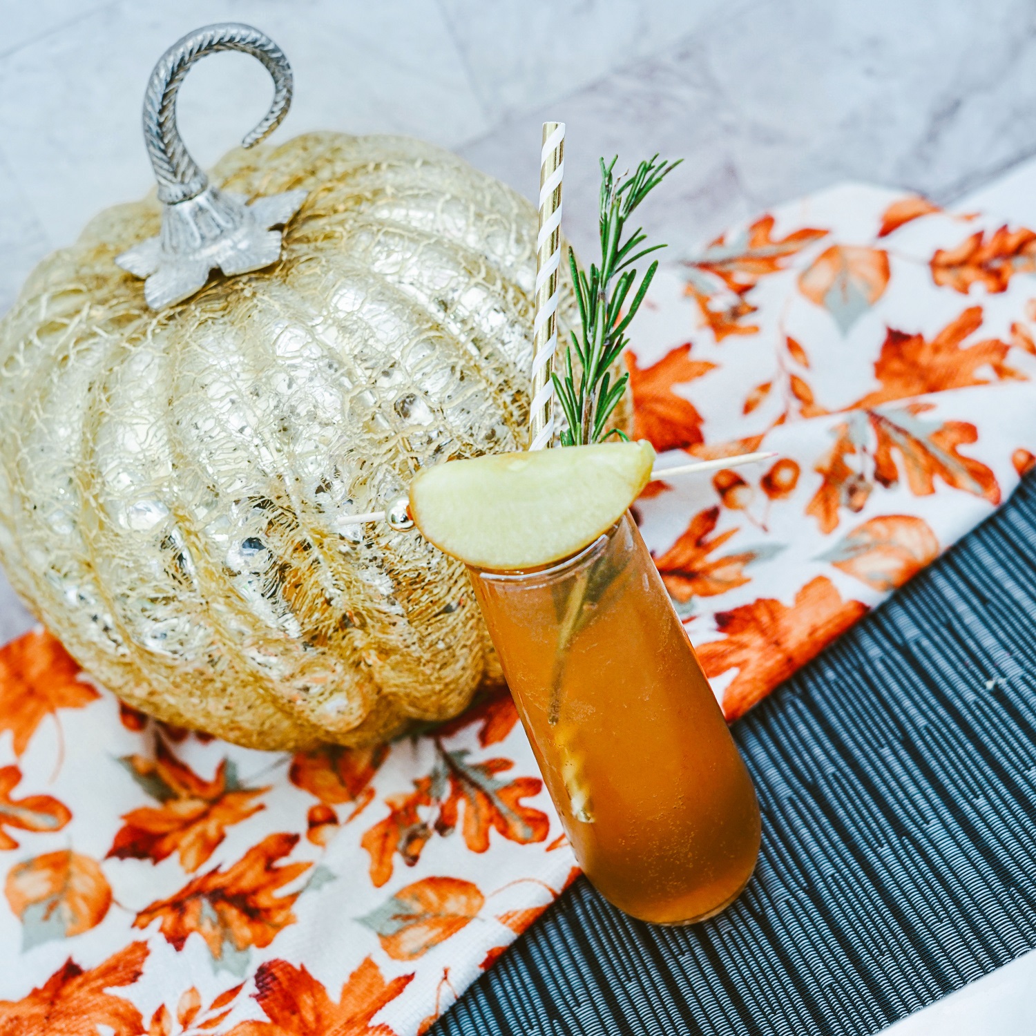 Cranberry Apple Mimosa in a fluted glass garnished with an apple wedge and rosemary sprig,