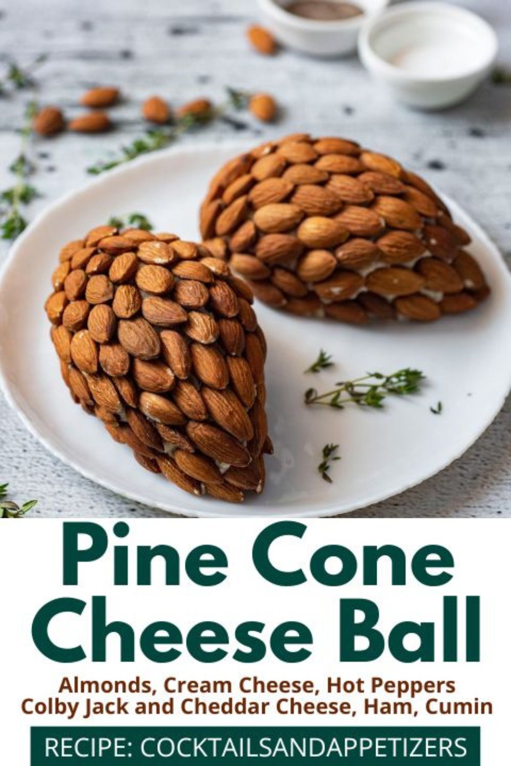 Pine Cone cheese balls sit on a white plate with herbs sprinkled around.