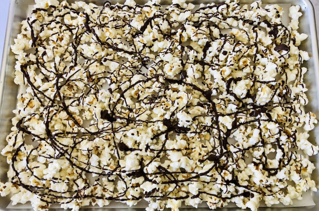 Melted chocolate drizzled over popcorn.