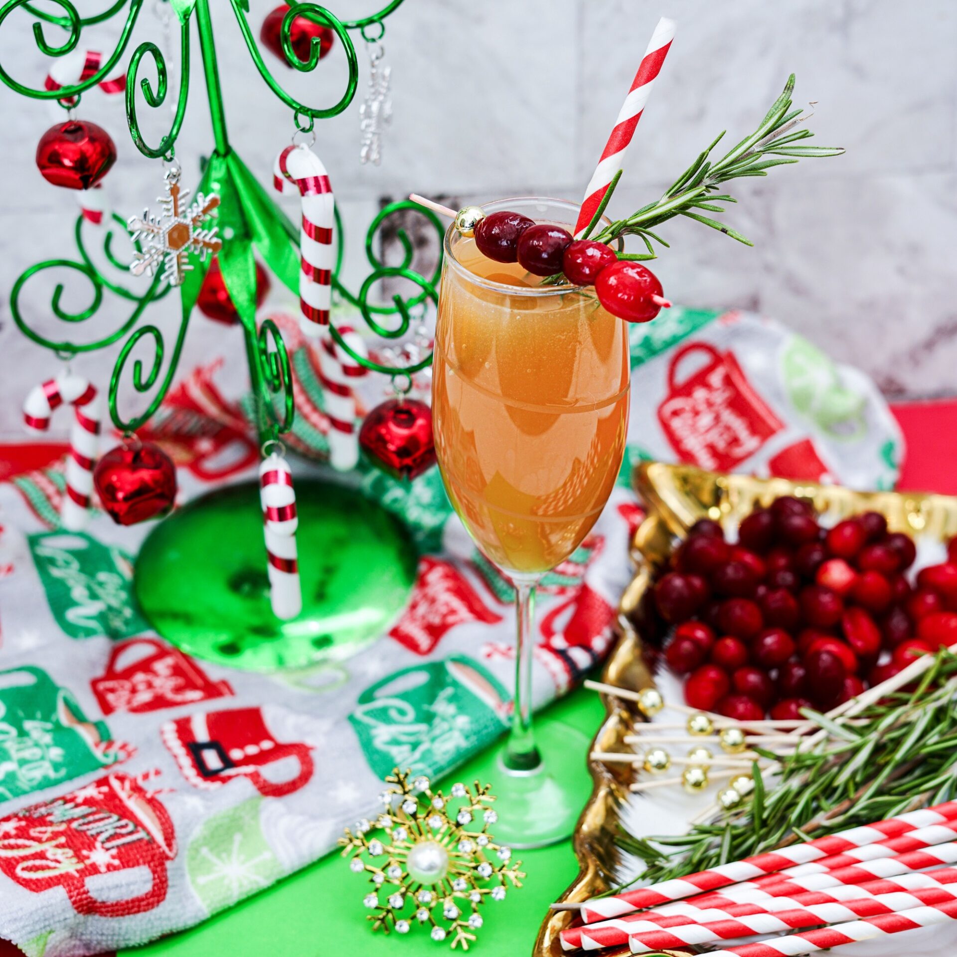Christmas mimosa drink in a champagne glass, garnished with fresh cranberries.