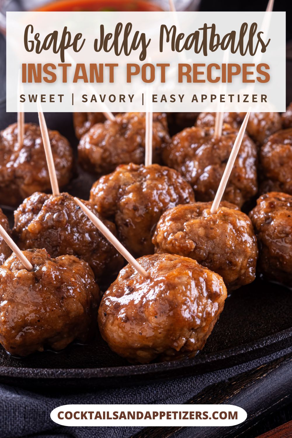 Grape Jelly meatballs with toothpick holders in them sitting on a tray.