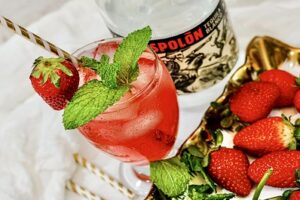 Sparkling Tequila Kiss with mint and strawberry garnish in a cocktail glass