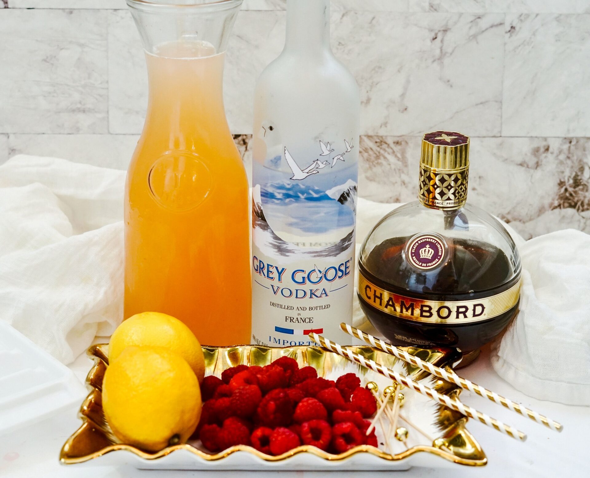 Ingredients for Vodka Raspberry Lemonade on a white countertop.