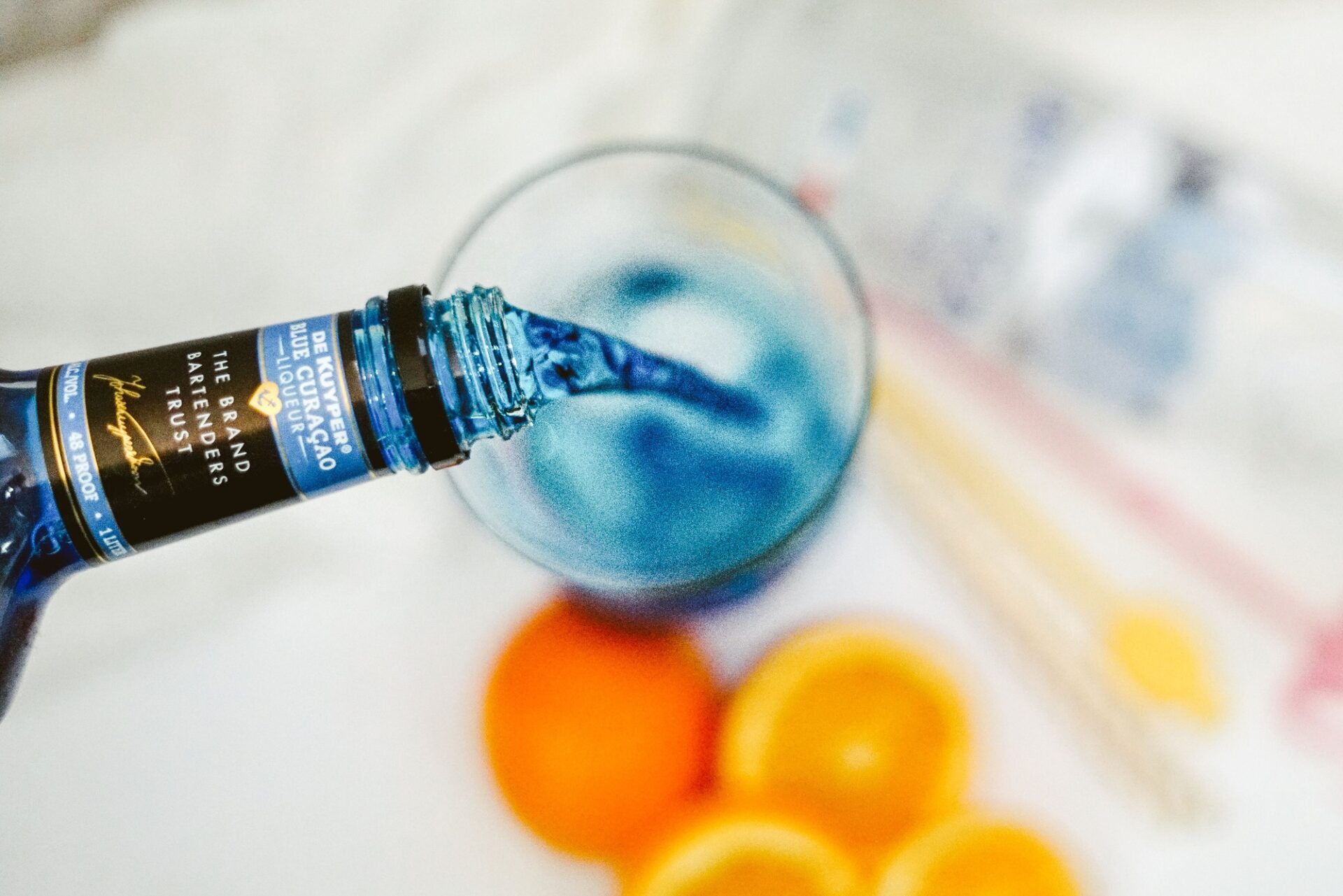 Pouring Blue Curacao into a glass.