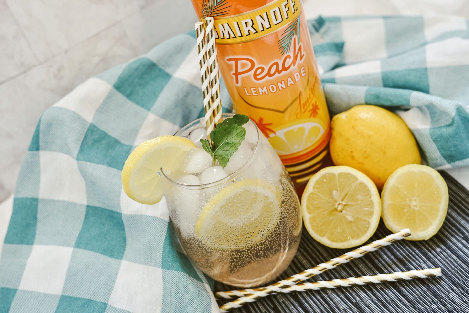 Peach lemonade vodka seltzer on a counter with ingredients.