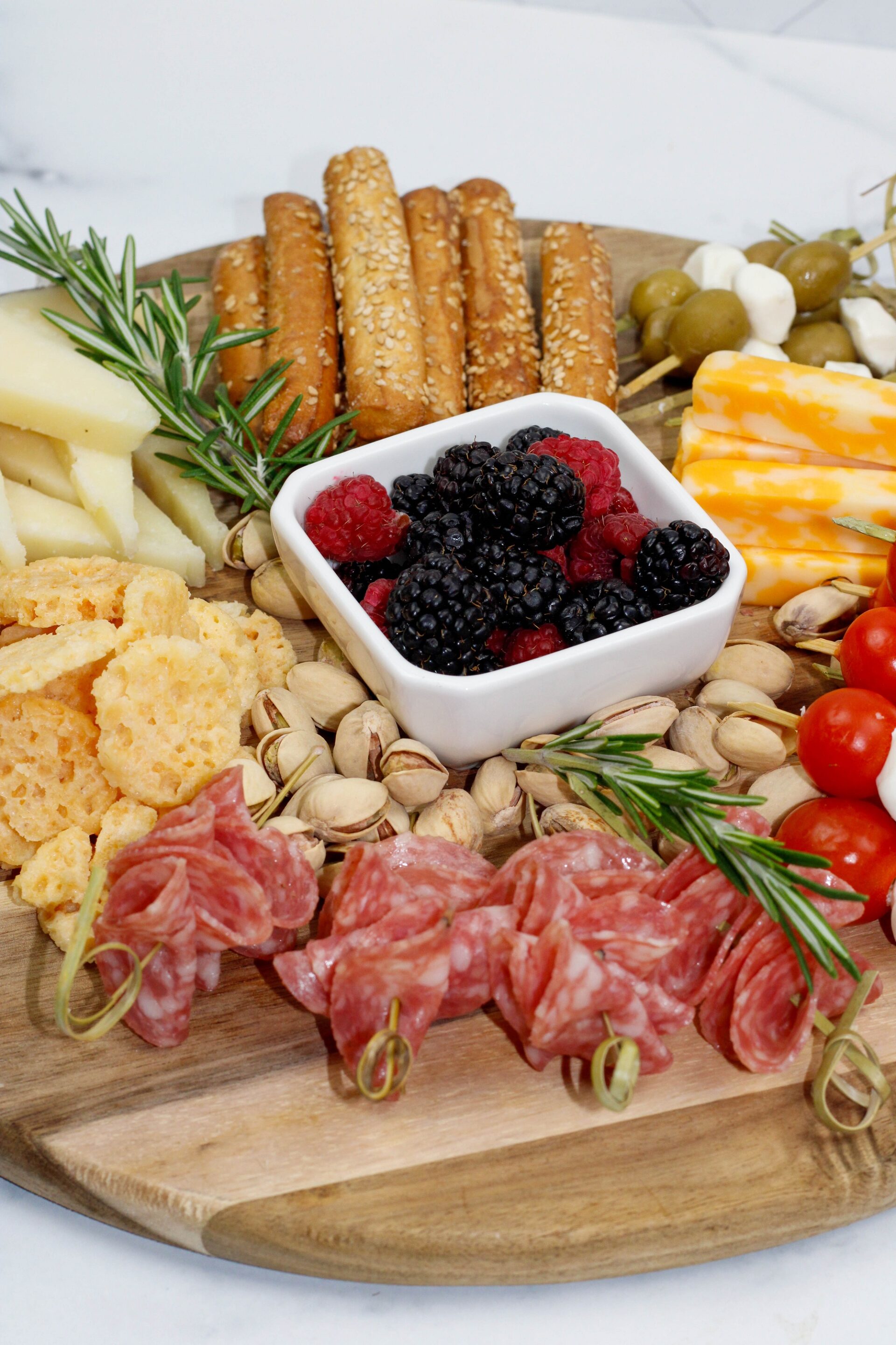 Charcuterie components on a wooden board.
