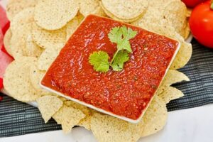 Chili's Copycat Salsa in a serving dish with tortilla chips around it