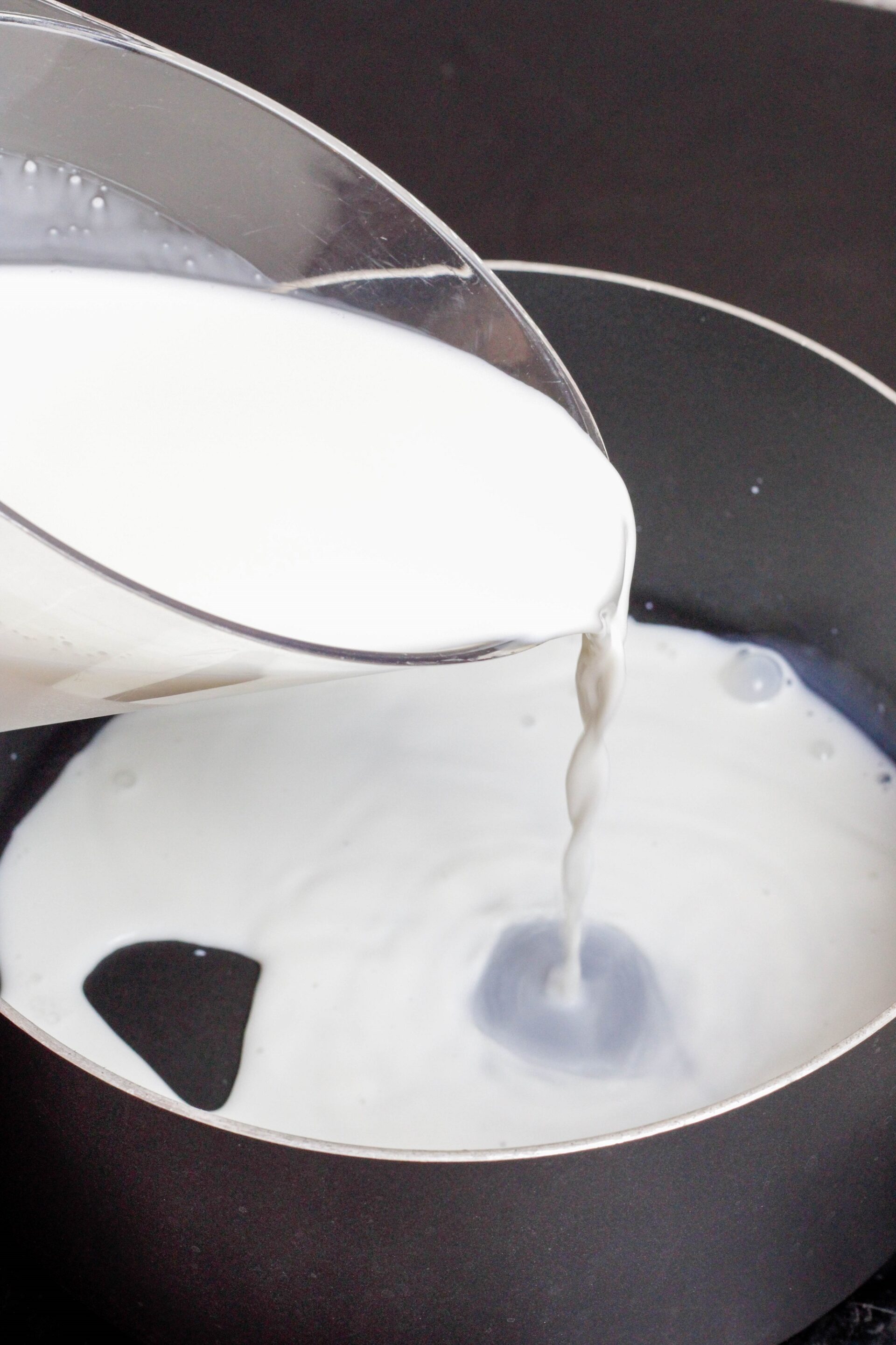 Pouring milk into a saucepan.