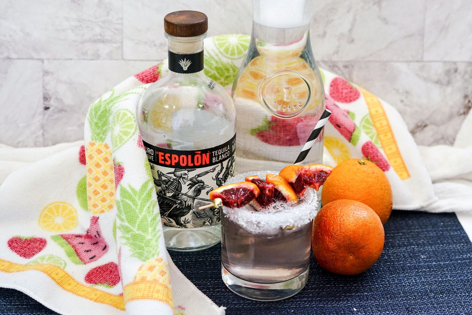 blood orange tequila spritzer on a counter with ingredients.