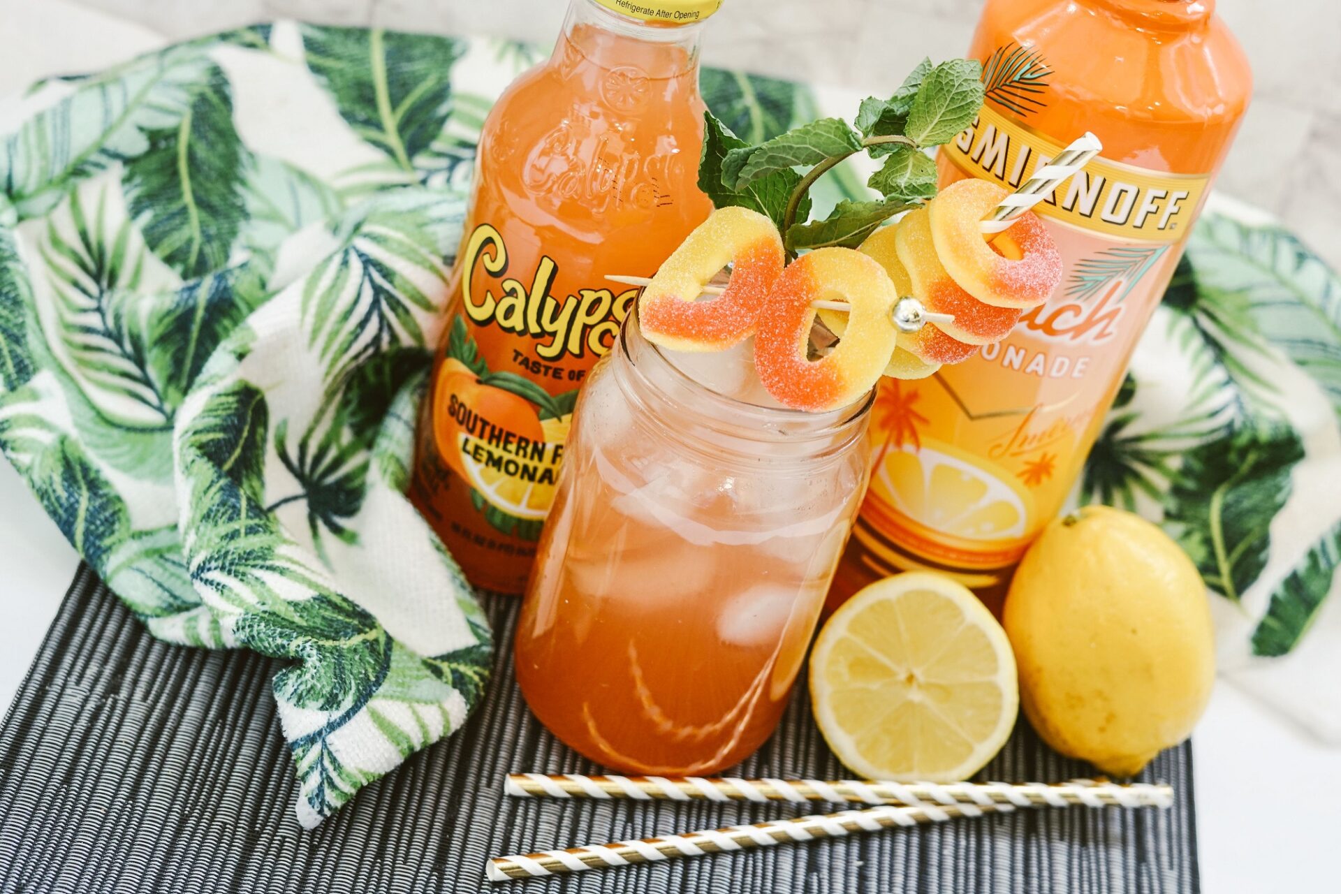calypso peach lemonade cocktail on a counter with ingredients.