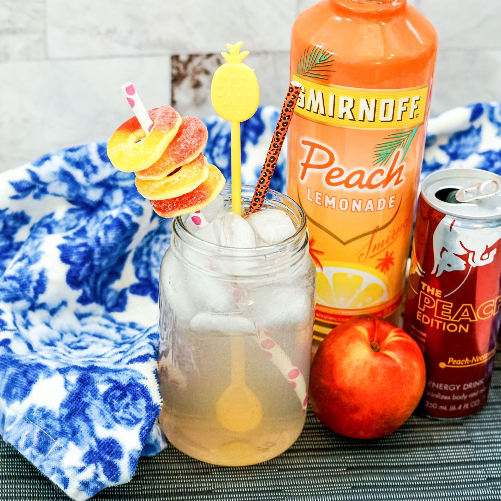 spiked peach red bull cocktail on a counter with ingredients