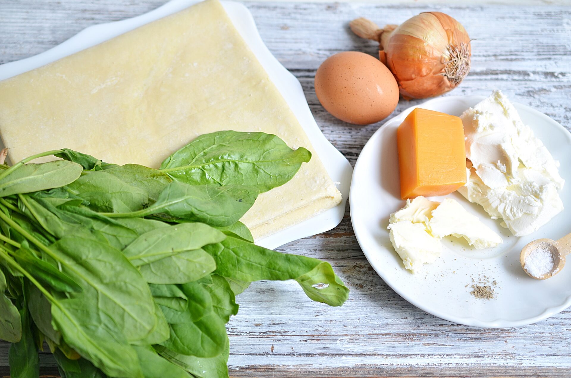 Ingredients for spinach and feta quiche on a counter.