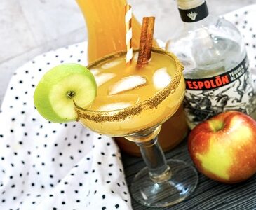 Apple Cider Margarita drink in a glass with apple garnish.