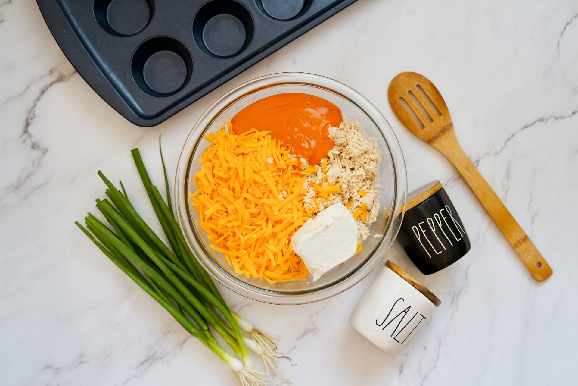 Combining ingredients for buffalo chicken filling.