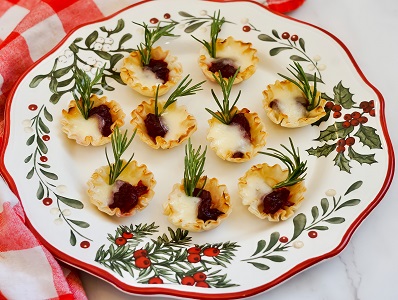 Cranberry Brie Bites with rosemary garnish on a plate.