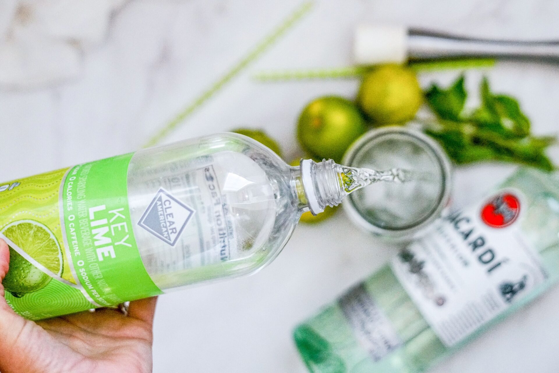 Pouring lime sparkling water into a glass.