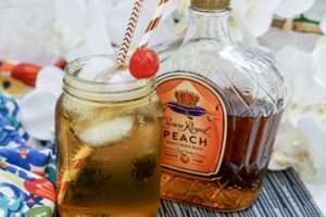 Peaches and Cream cocktail with bottle of Crown Royal in background.
