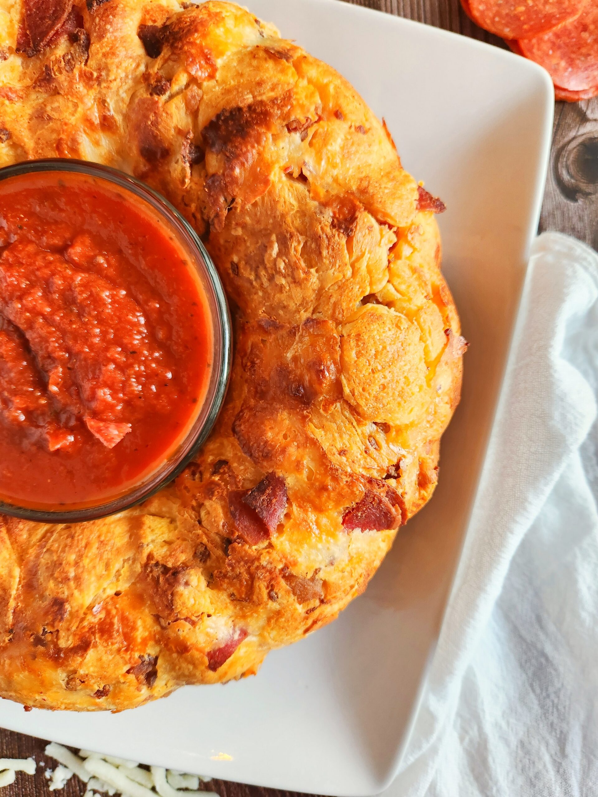 Baked pizza pull apart bread on a serving platter with marinara.