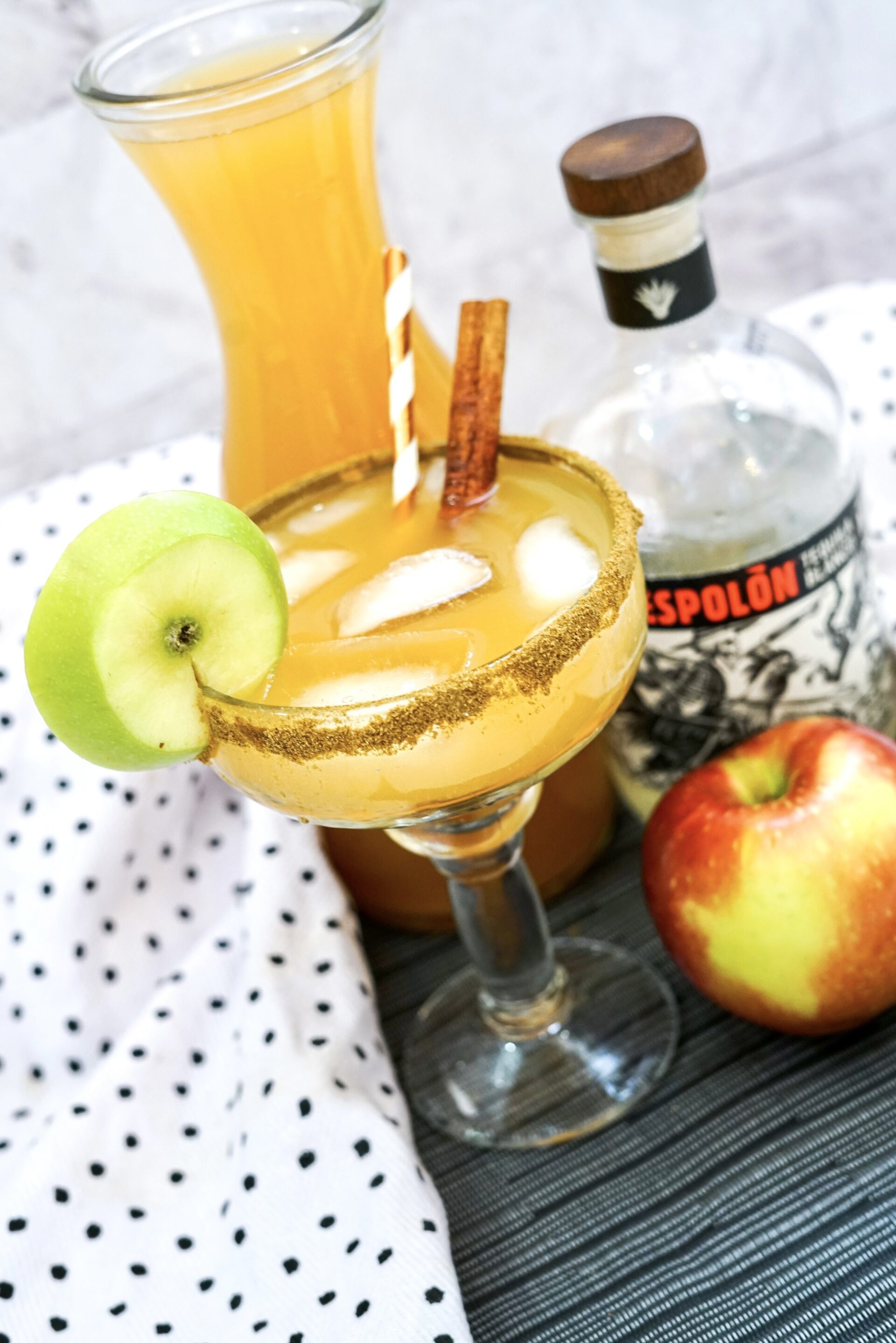 Apple cider margarita on a counter with ingredients.