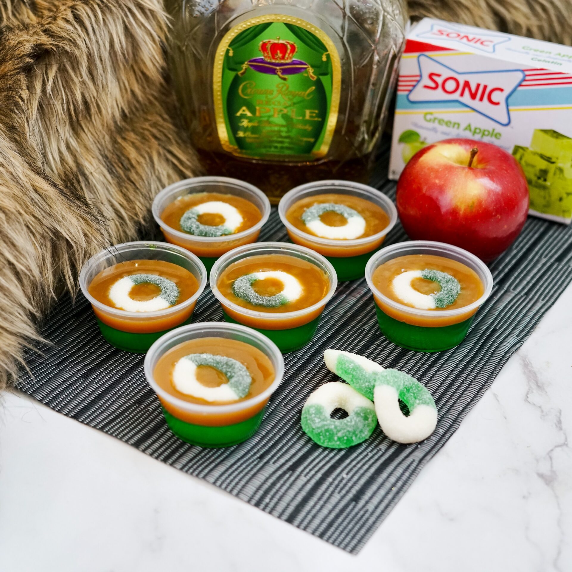 Caramel apple jello shots on a counter with ingredients.