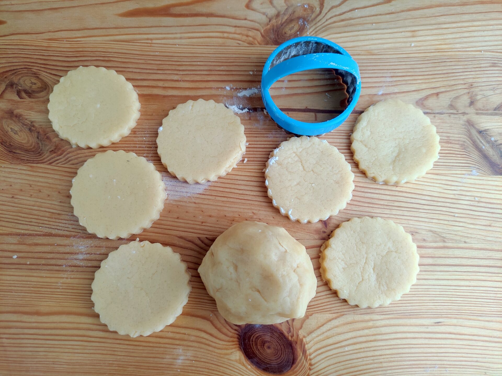 Cutting cookies into circles with a cookie cutter.
