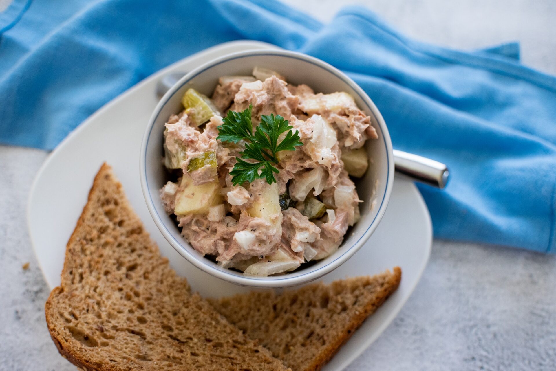 Easy tuna salad in a bowl on a plate with bread.