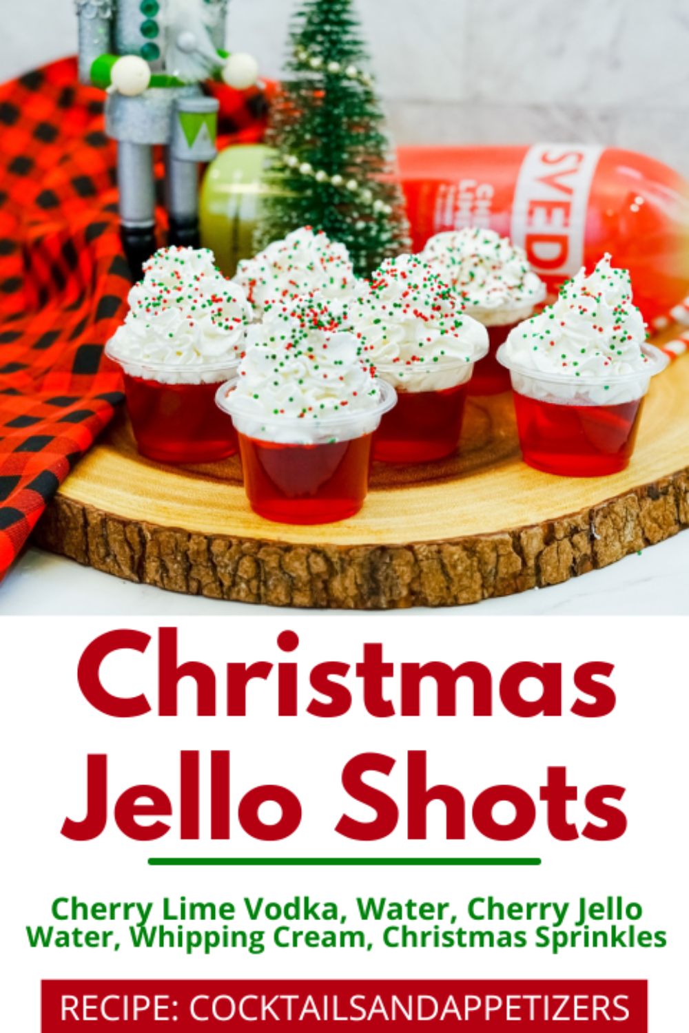 Christmas Jello shots with whipped cream topping and sprinkles on a wood slab.