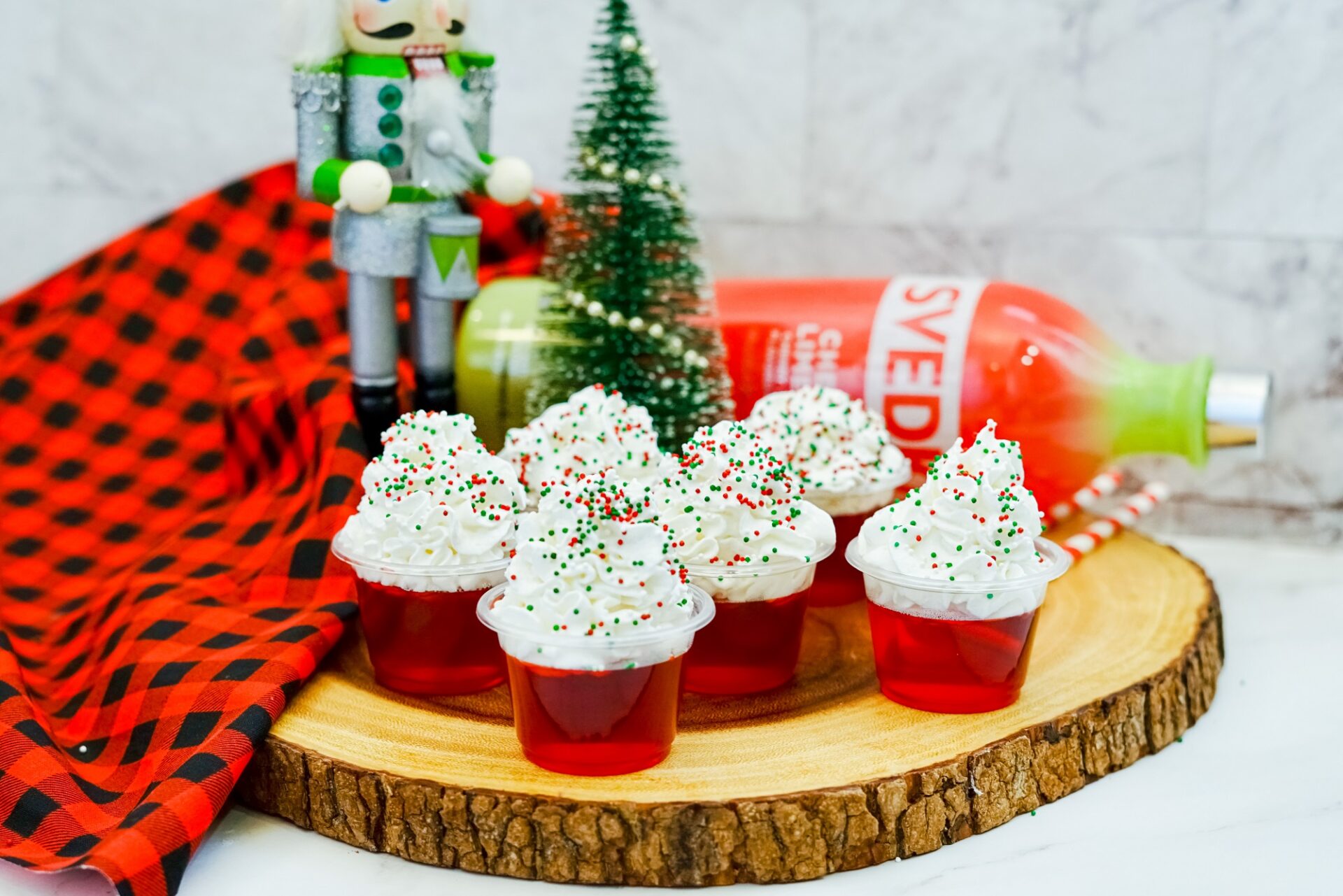 Christmas jello shots on a serving board with ingredients.