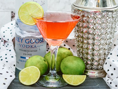 Cosmopolitan Cocktail in a glass with lime garnish.