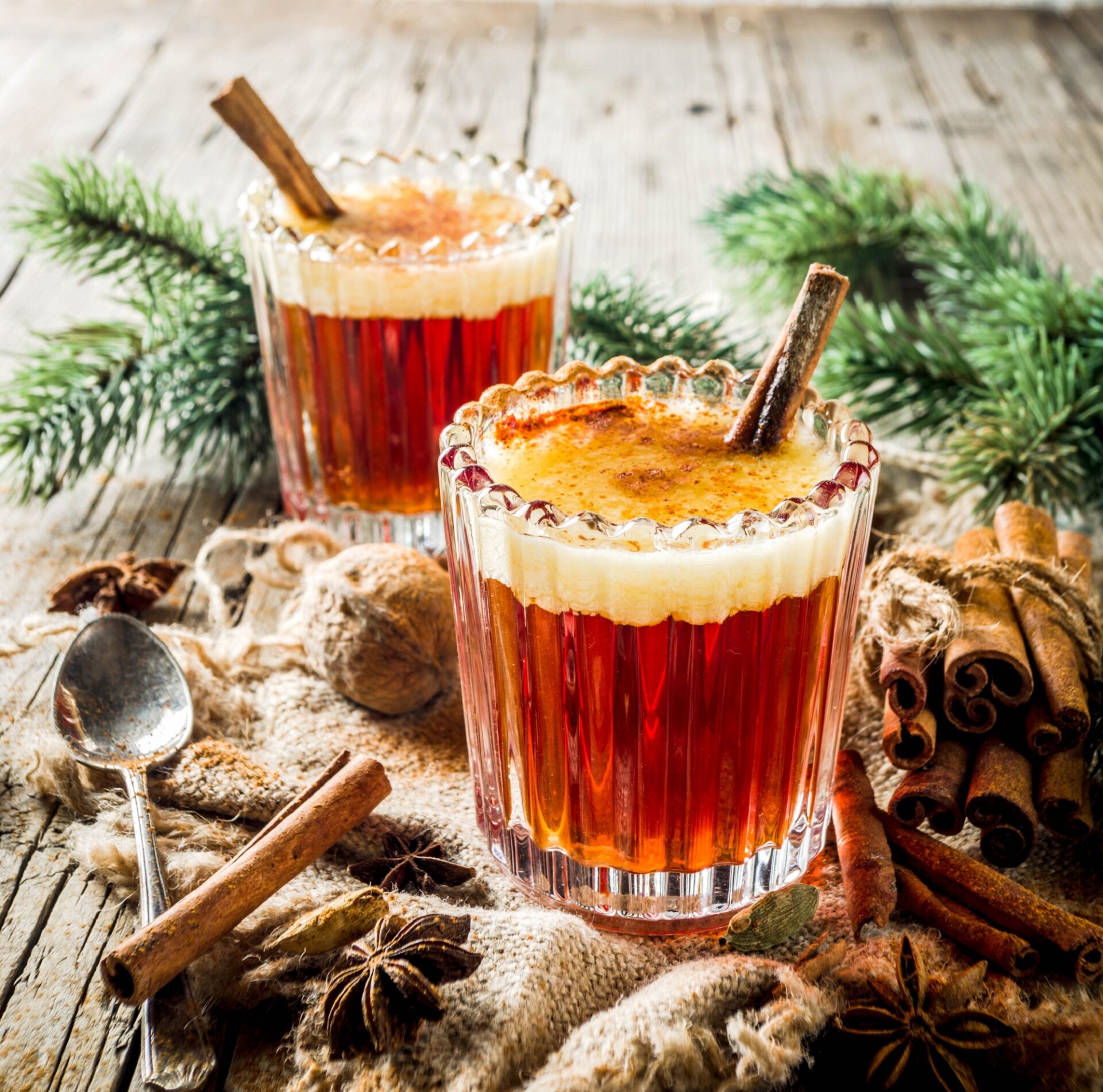 Hot buttered rum on a counter with wintry decor.