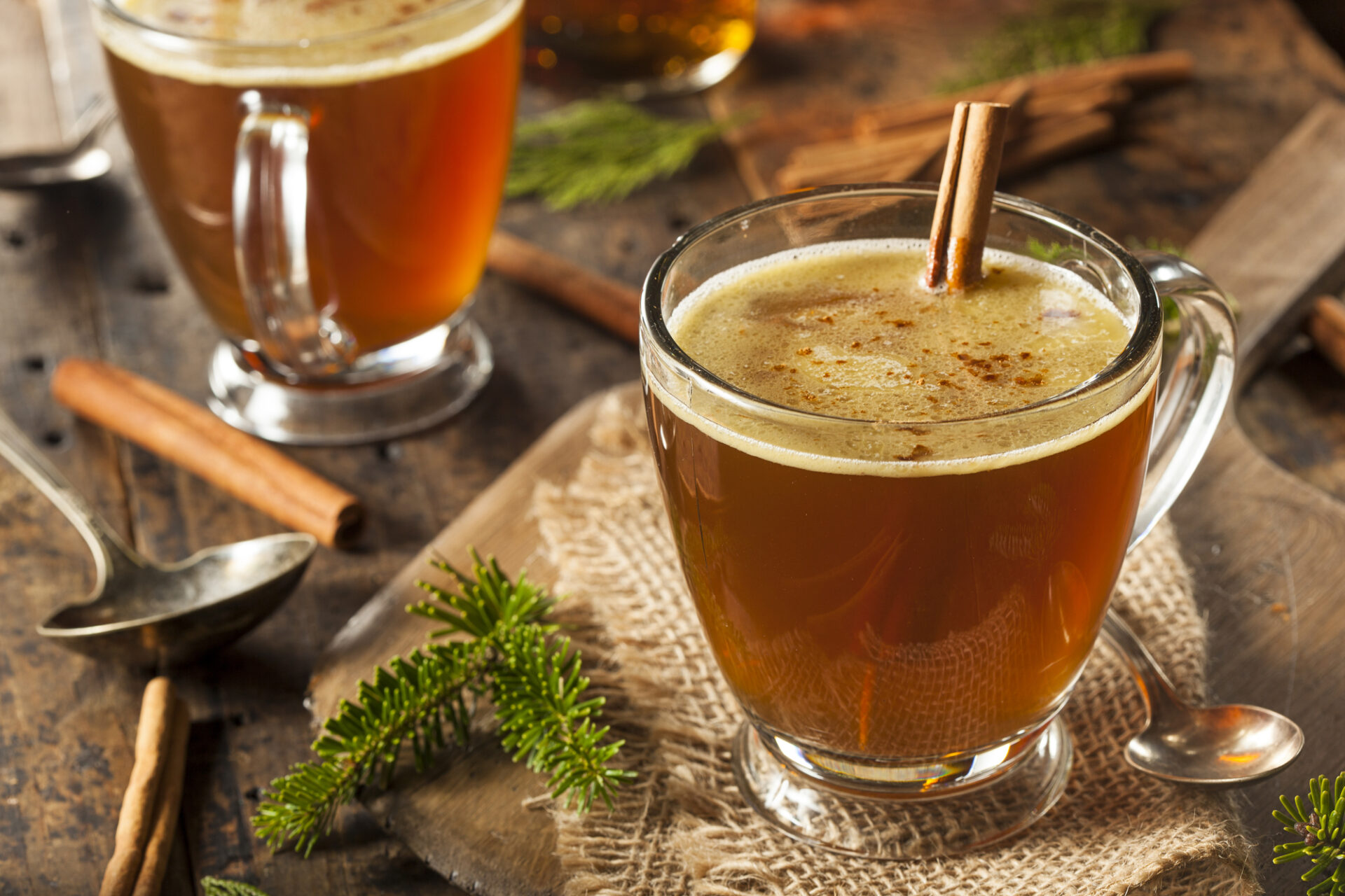Hot buttered rum on a counter with wintry decorations.