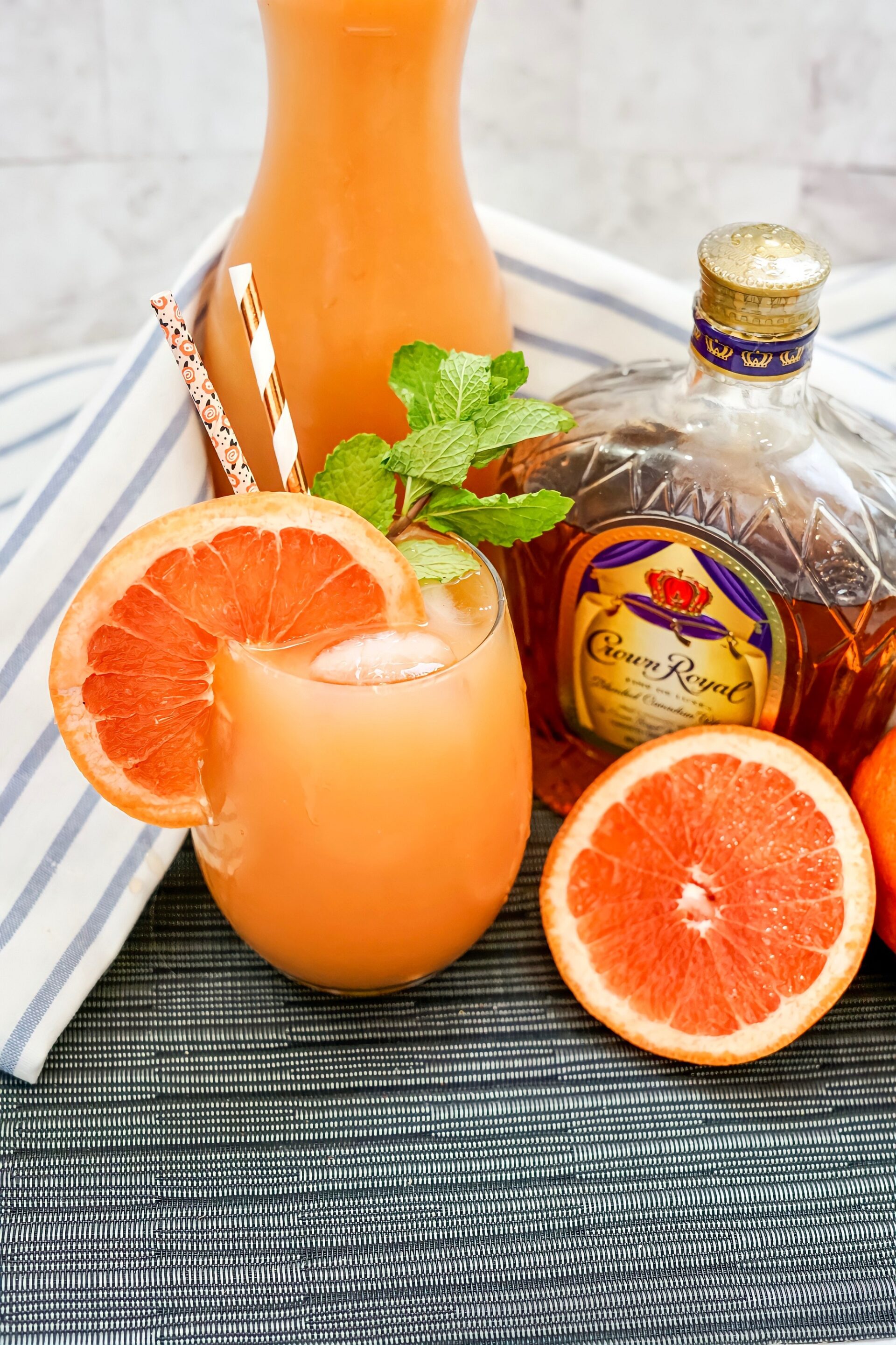 Crown Royal Whiskey Grapefruit Smash in a glass with grapefruit slice garnish and mint.