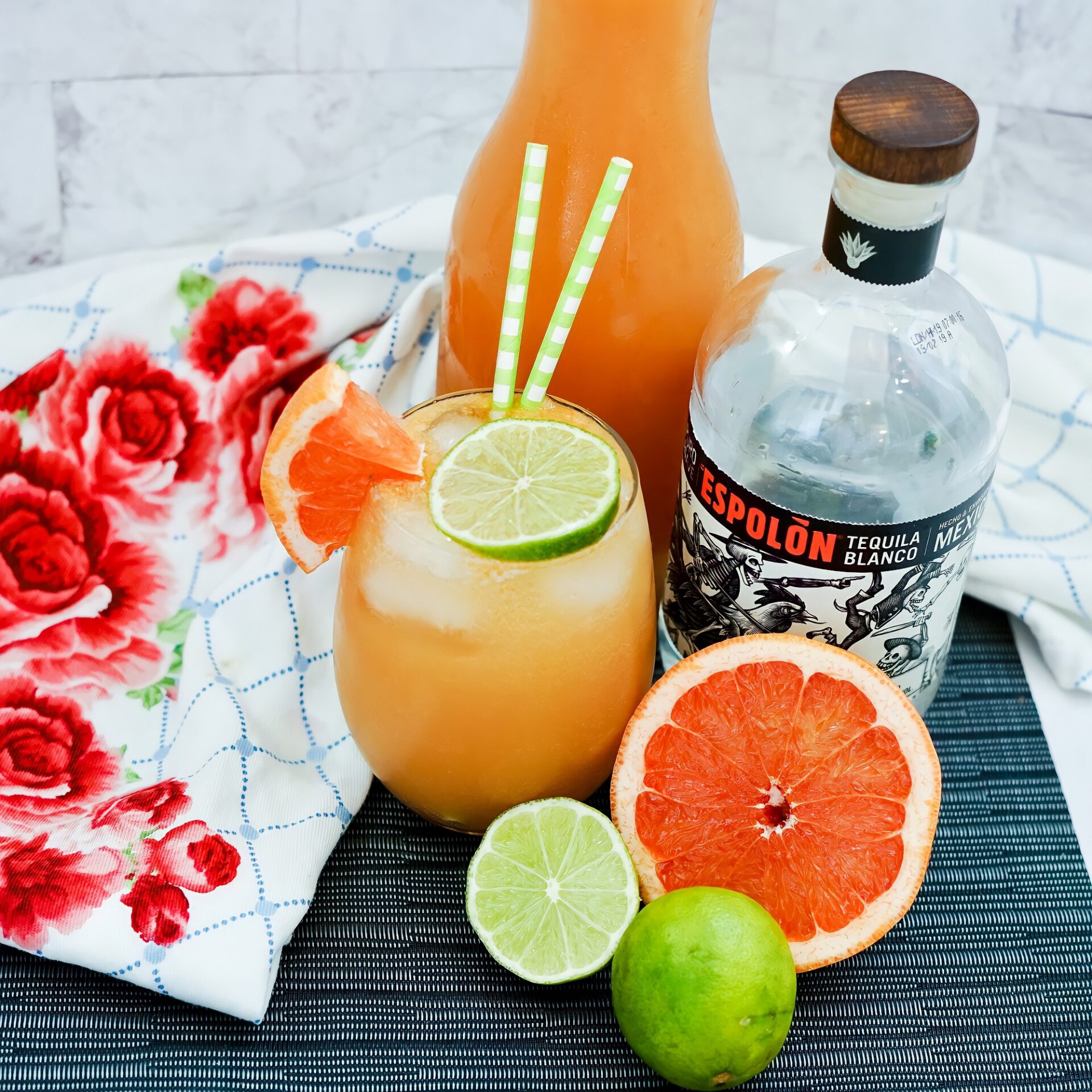 Paloma cocktail on a counter with ingredients.
