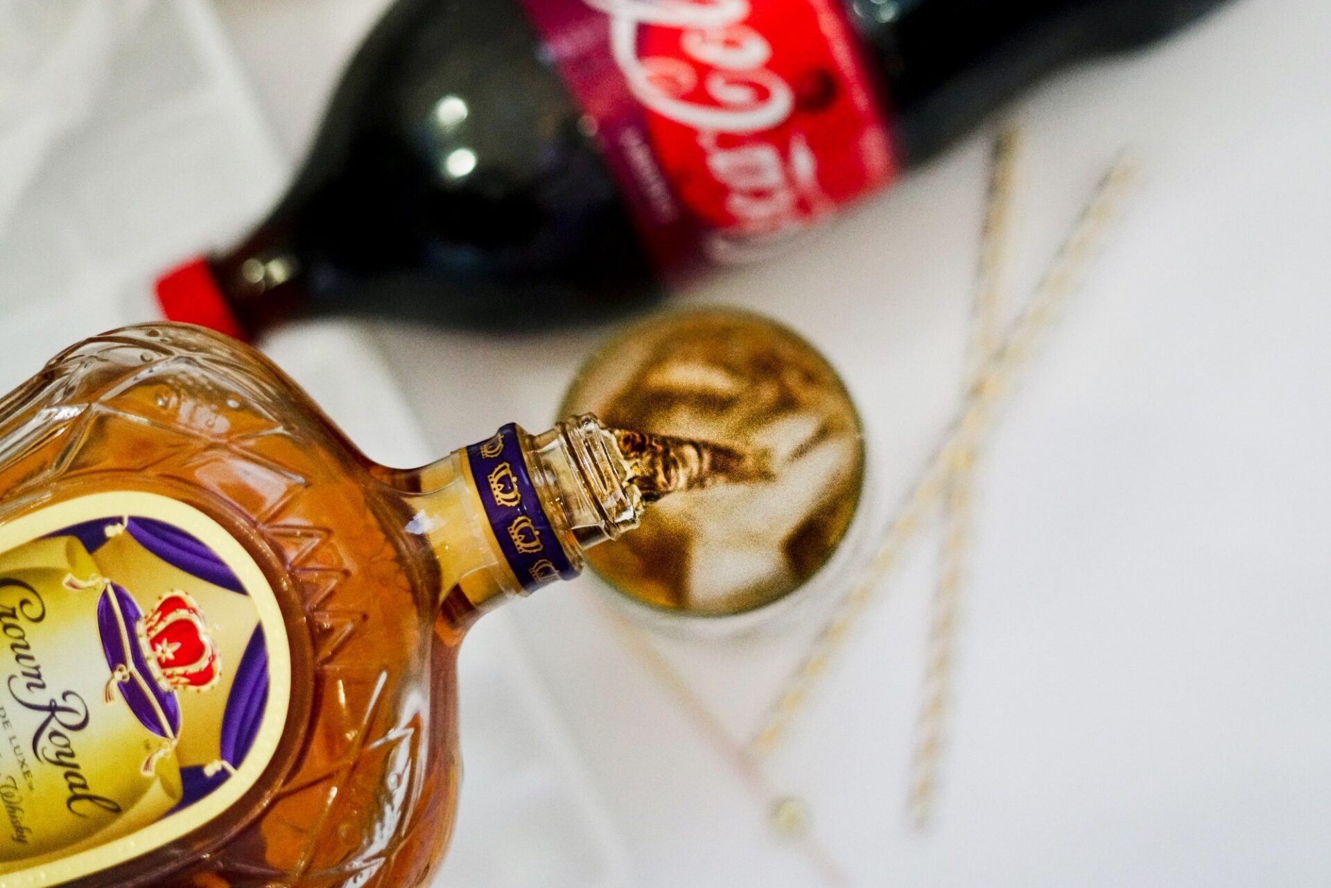 Pouring crown royal whiskey into a glass.