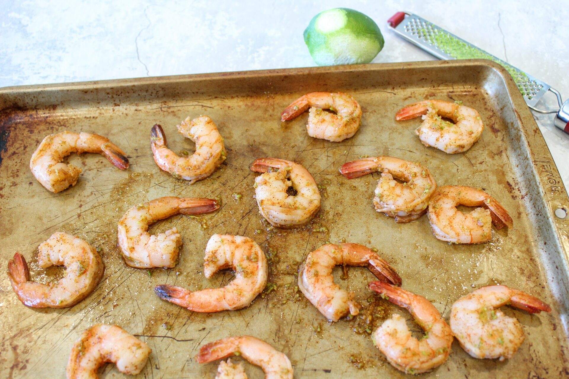 Cooked shrimp on a baking sheet.