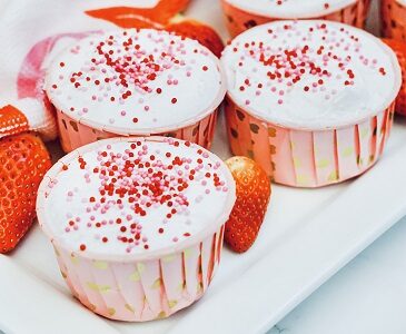 Baileys Strawberries and Cream Pudding Shots with sprinkles on top.