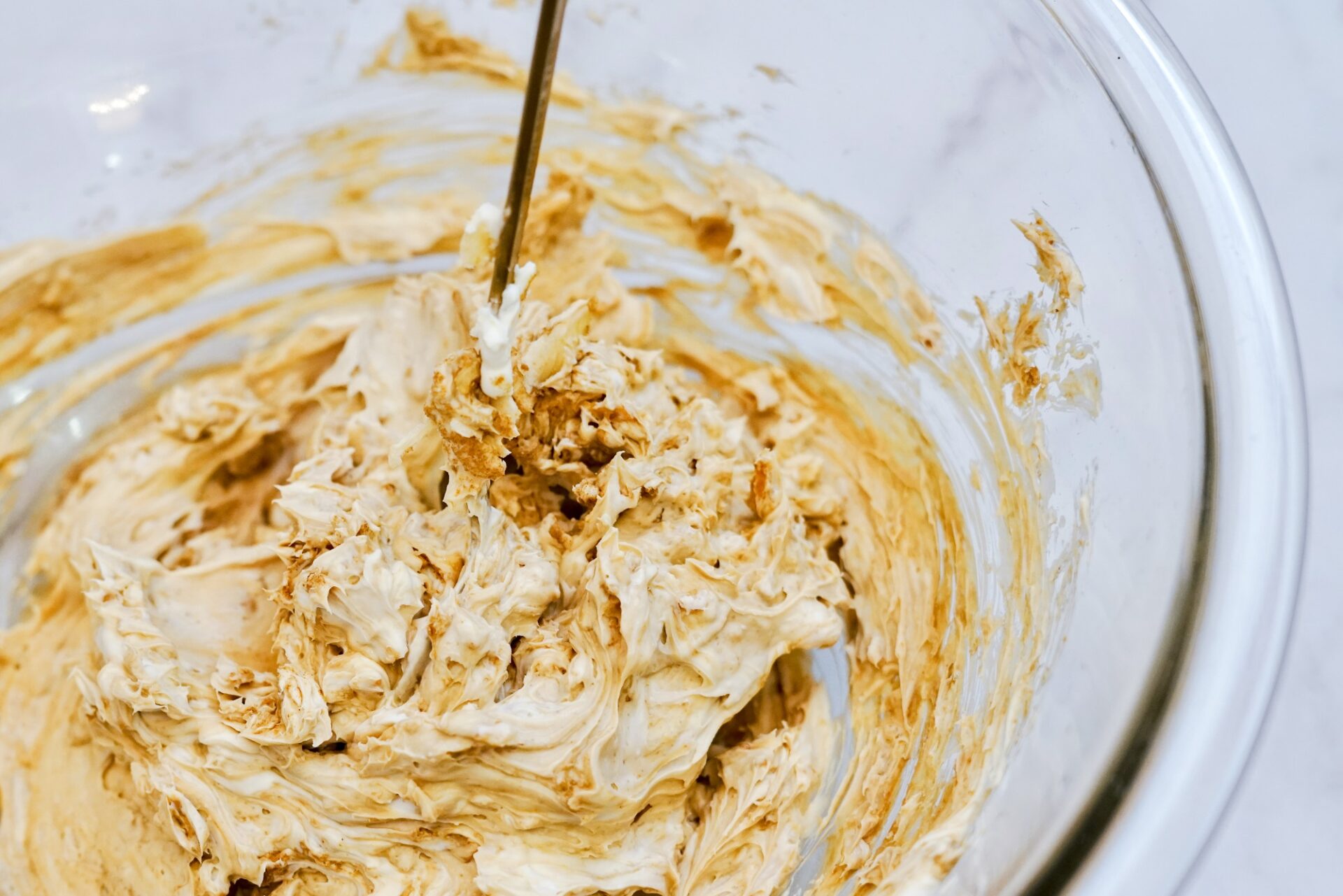 Mixing cream cheese and onion dip mix in a bowl.