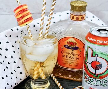 Crown Royal Peach Bang drink with gummy ring garnish and pretty straws.