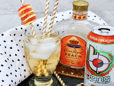 Crown Royal Peach Bang drink with gummy ring garnish and pretty straws.