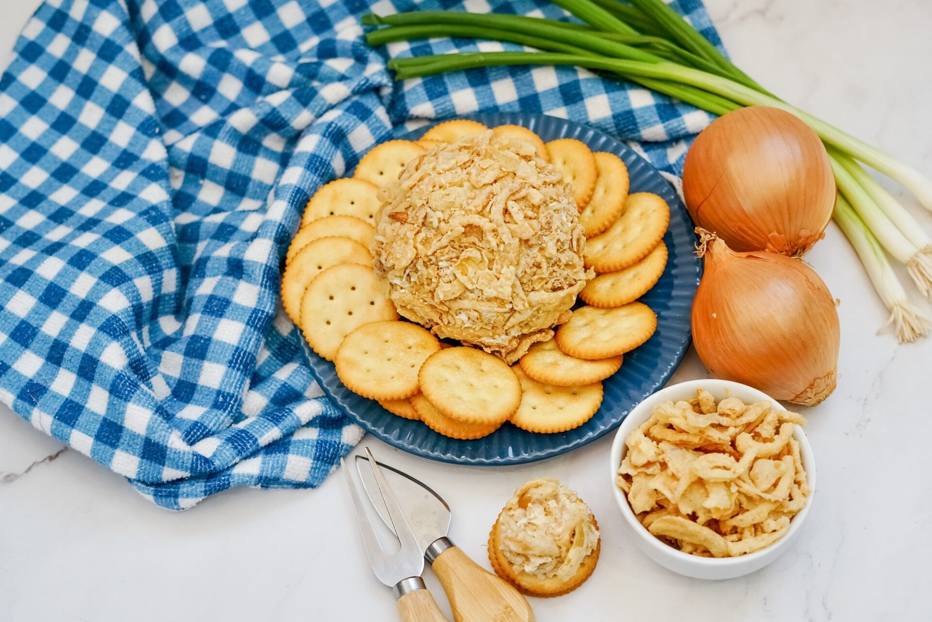 French onion cheese ball on a plate with crackers.