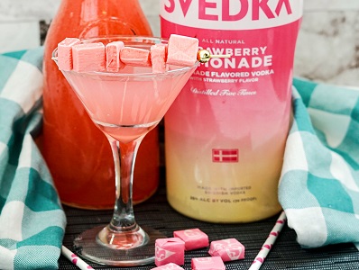 Strawberry Lemonade Vodka Starburst drink in a martini glass with candy skewer