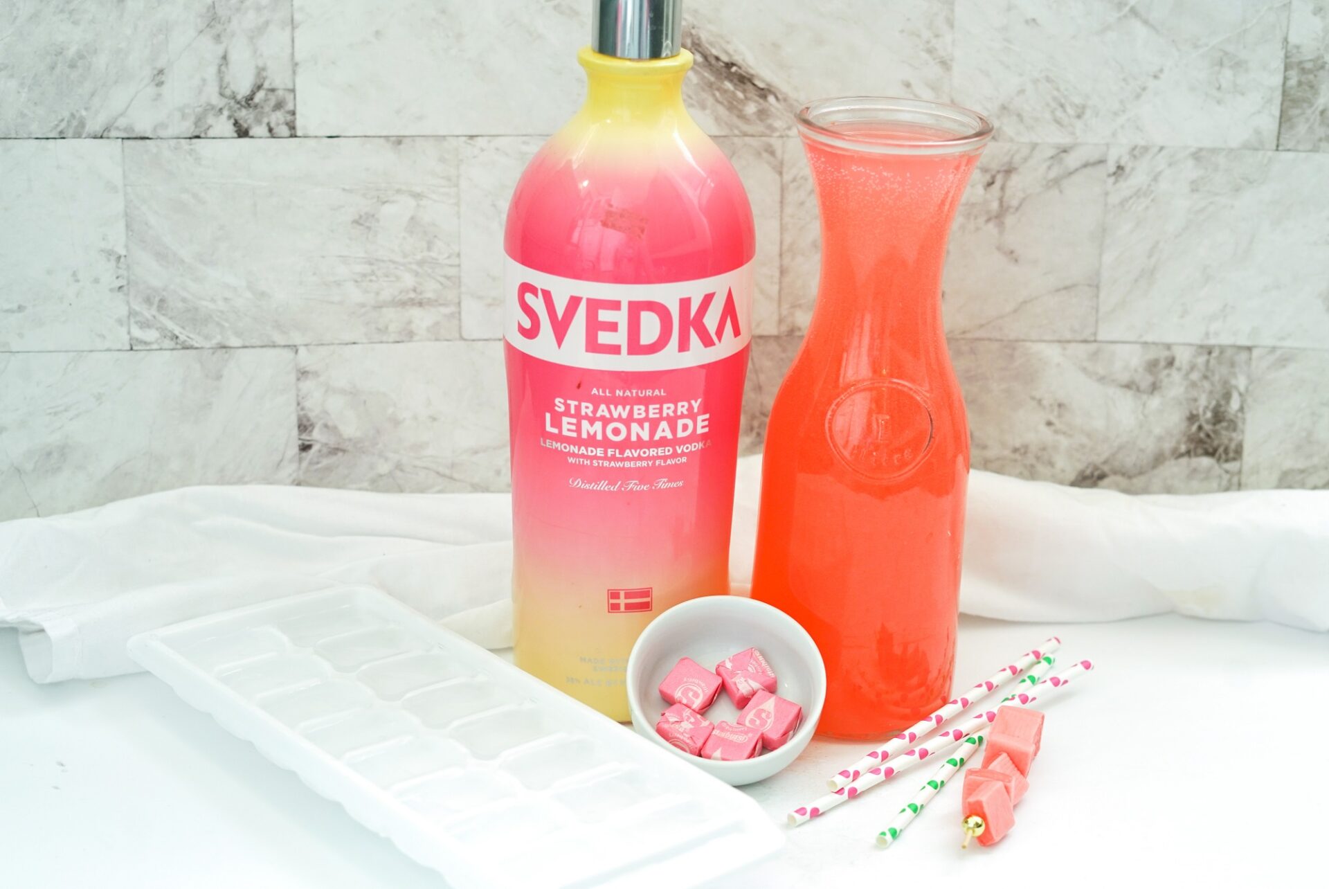 Ingredients for strawberry lemonade vodka starburst cocktail on a counter.