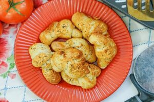 Air Fryer Garlic Knots baked and set on a red plate