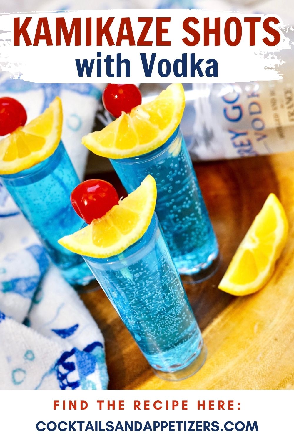 Blue Kamikaze shots in shot glasses with lime and cherry garnish.