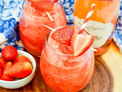 Strawberry Frose in a glass with strawberry garnish and colorful straw.