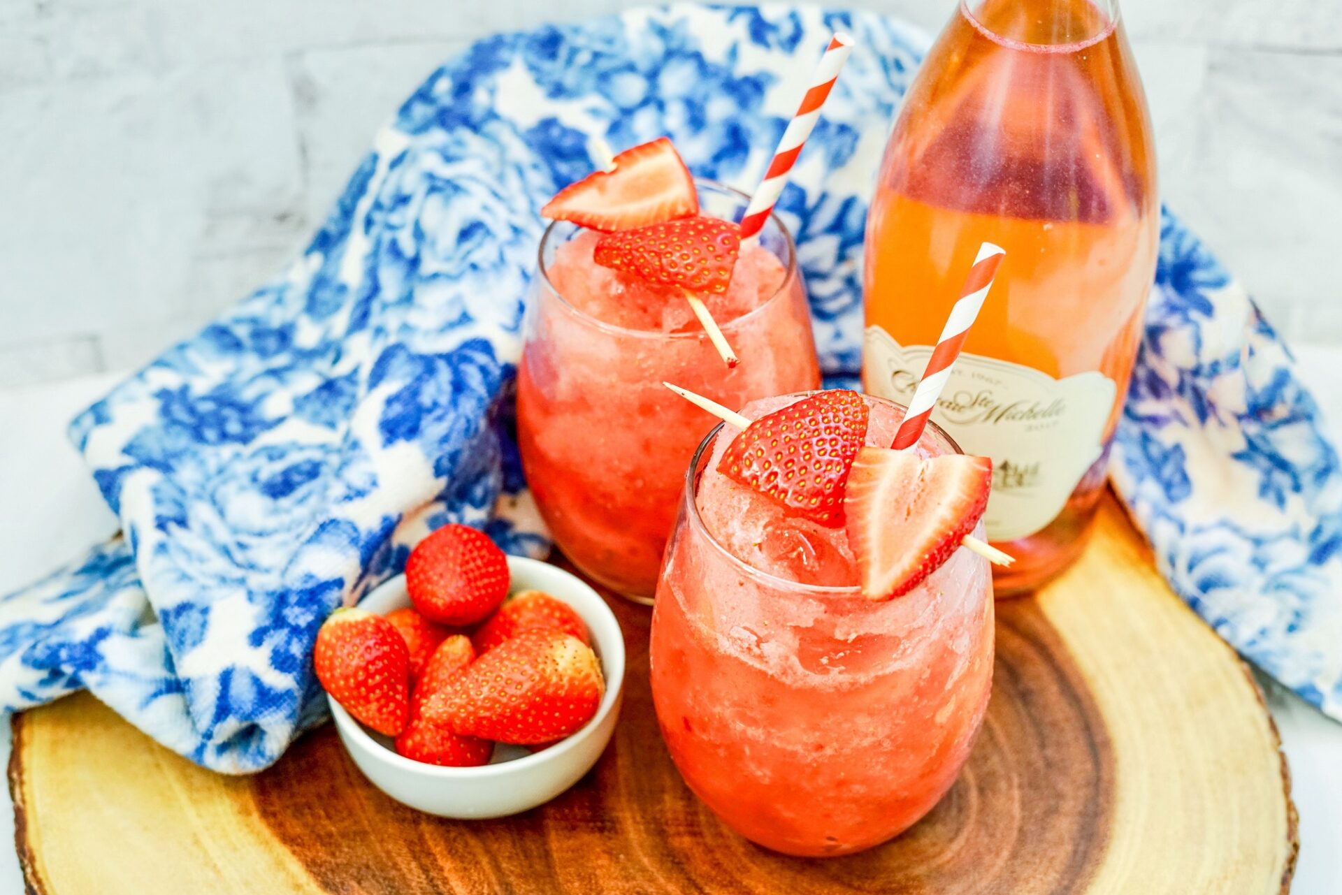 Strawberry frosé cocktails on a counter with ingredients.