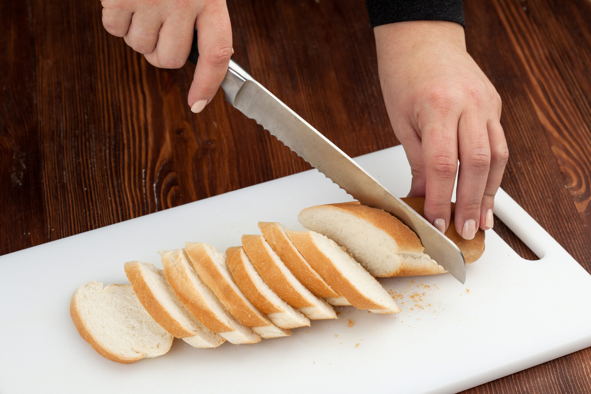 Cutting a baguette into slices.