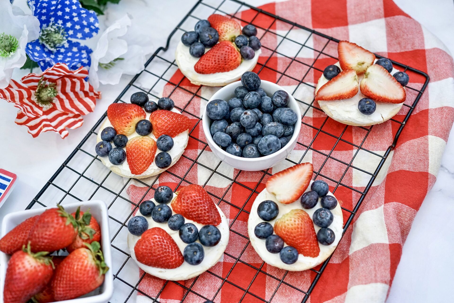 Mini Fruit Pizza with strawberries and blueberries on a cooling rack.