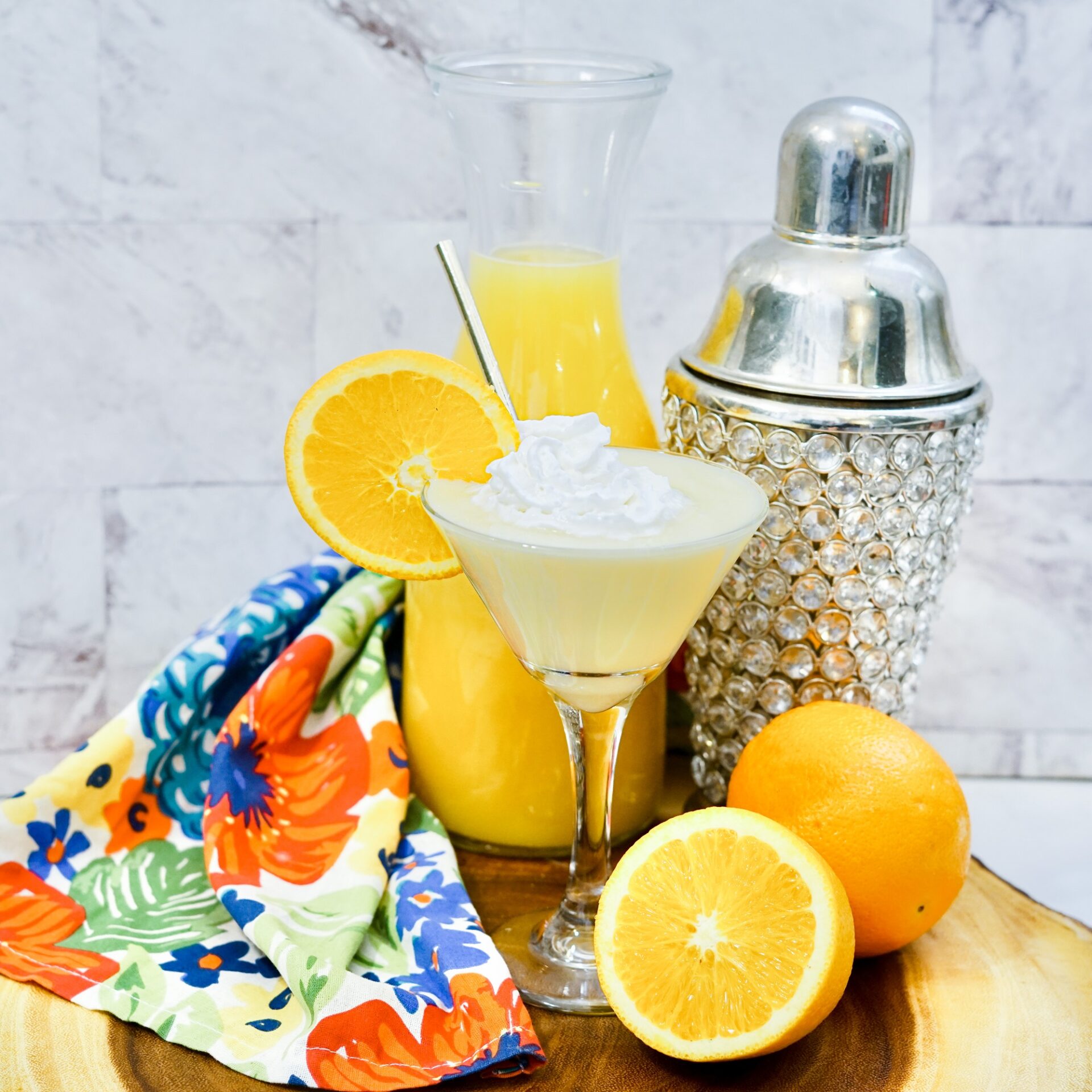 Orange creamsicle martini on a counter with ingredients.